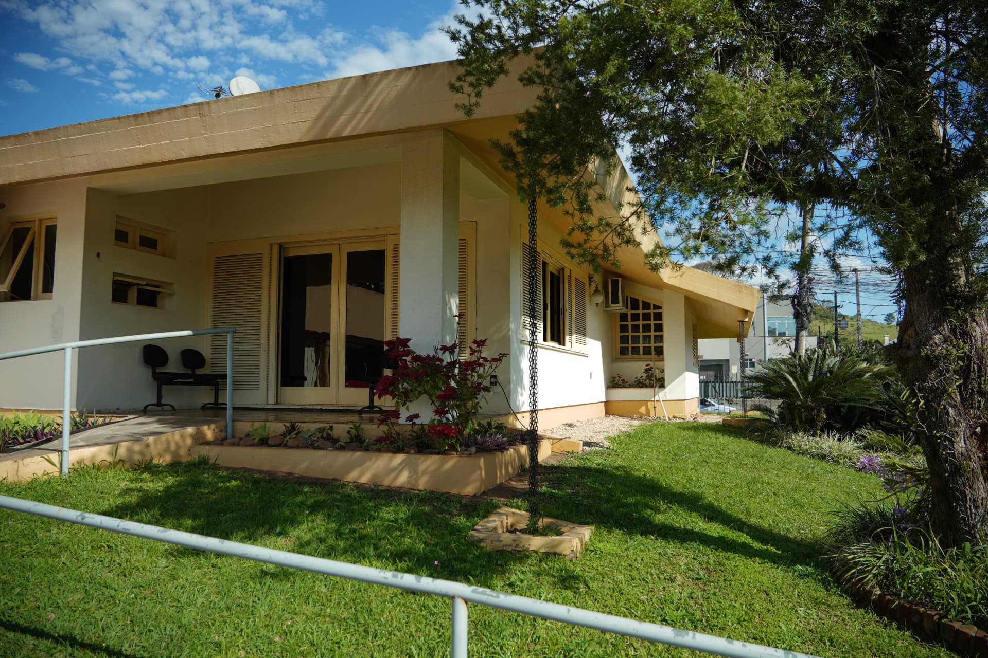 Fachada da Aconchego com jardim e rampa de acesso